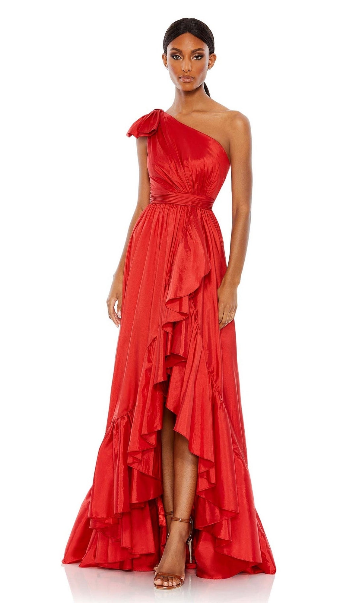 A woman models the Mac Duggal Long Formal Dress 68027—a red, one-shoulder gown with ruffle tiers and a high-low hem—paired with strappy heels, set against a plain white background.